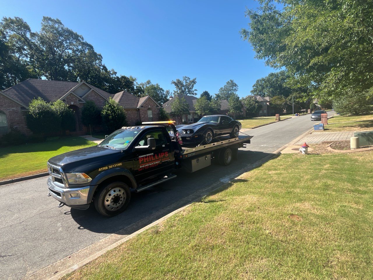 Phillips Bros. flatbed loading a car in a Little Rock neighborhood