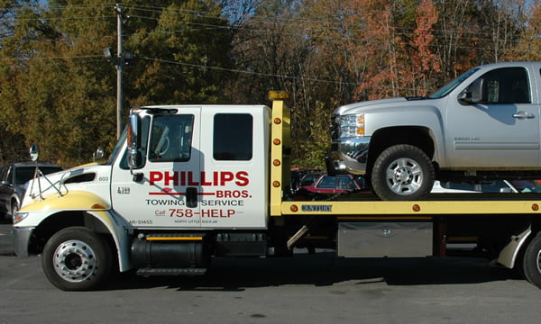 Phillips Brothers Towing flatbed with a pickup truck loaded